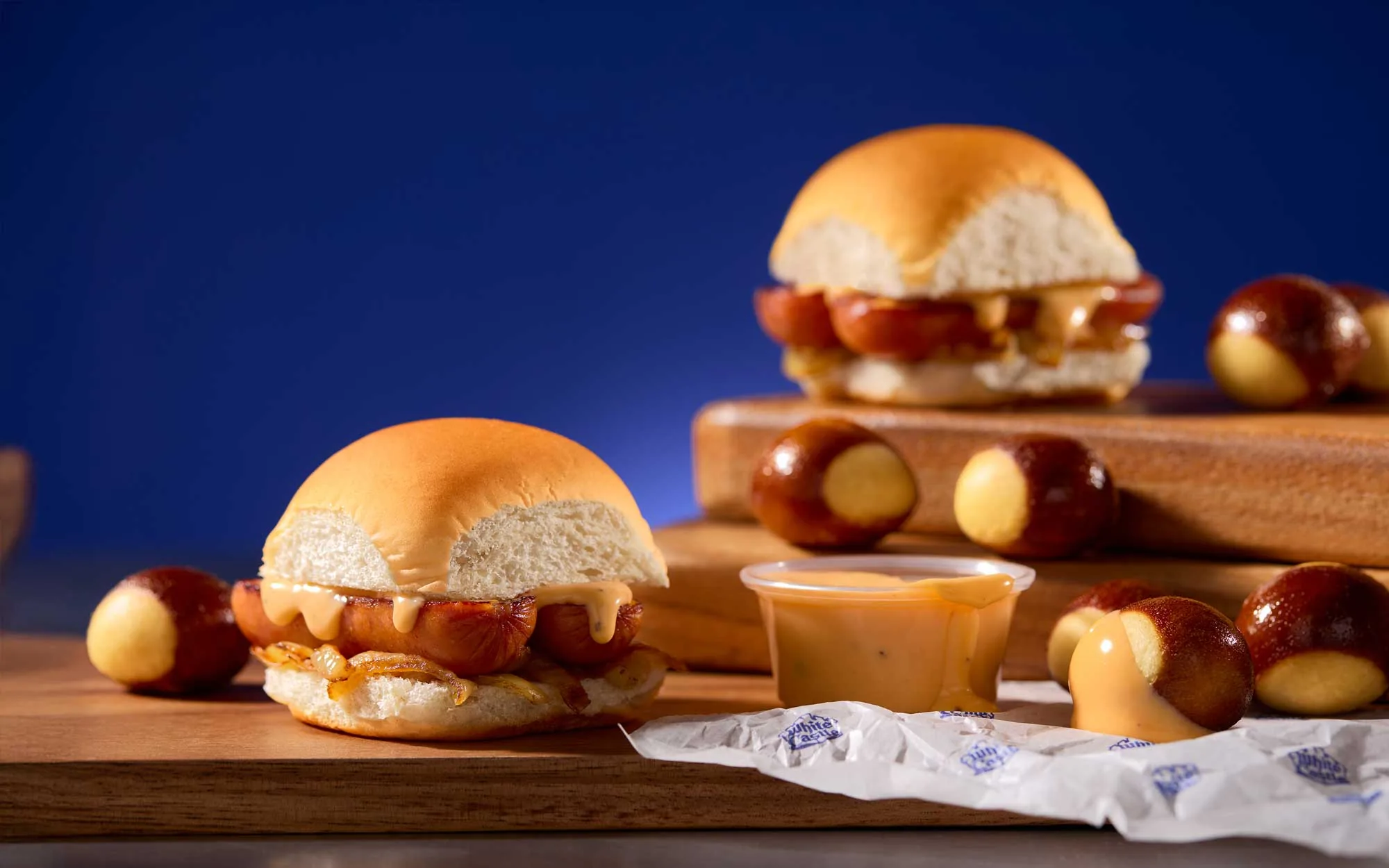 Cheese sausage sliders and pretzel bites on a blue backdrop